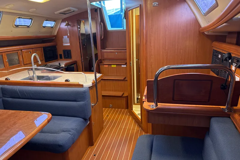 Murrelet Yacht Photos Pics Interior of 2009 Hunter 38 sailboat with kitchen, seating, and wooden cabinetry.