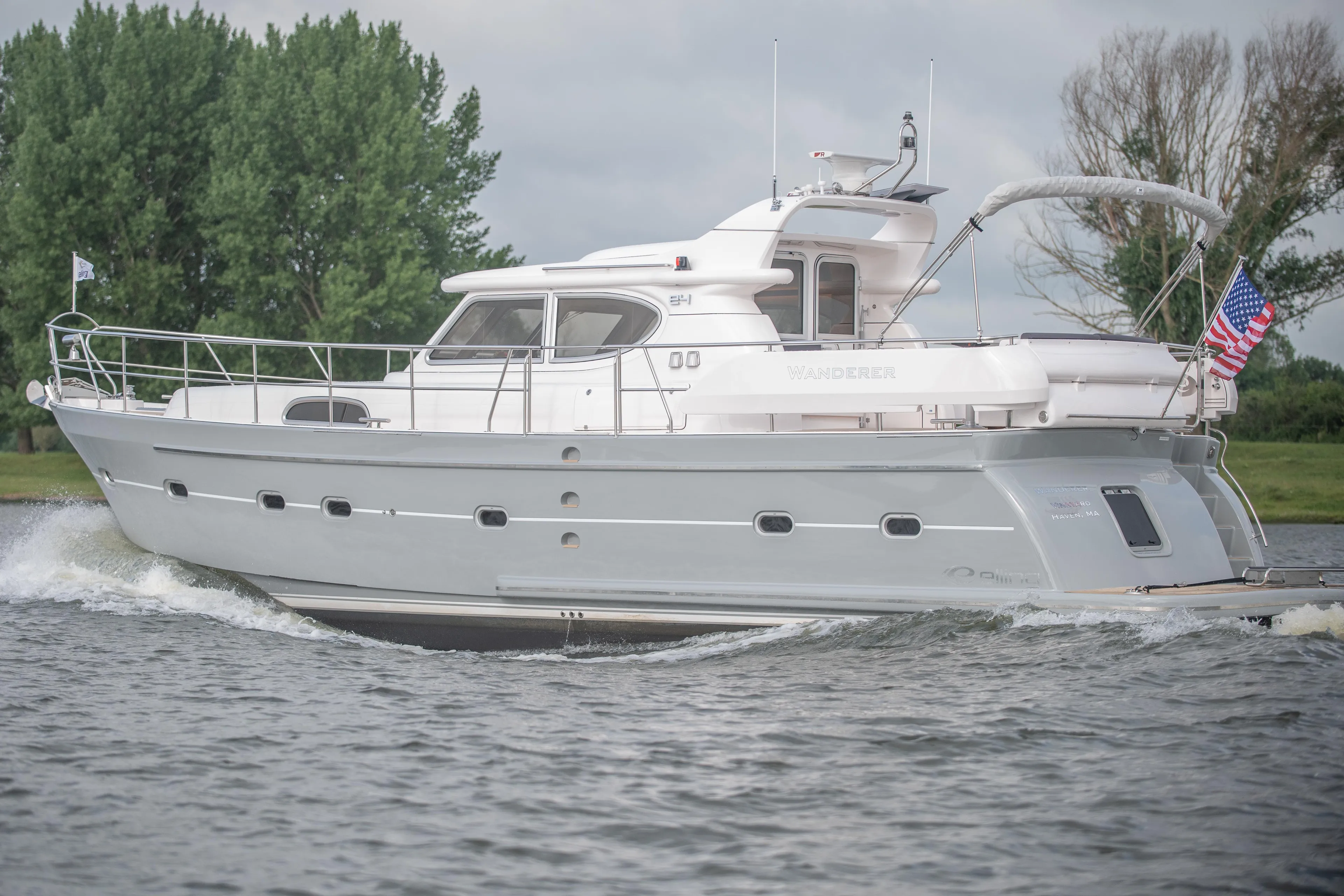 2026 Elling E4 yacht cruising on a river with trees in the background.