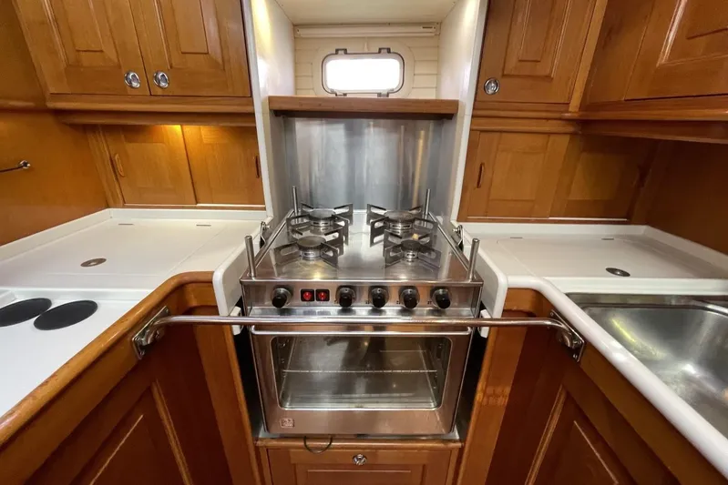  Yacht Photos Pics Galley kitchen in 1999 Baltic 73 Pilothouse yacht with stove and wooden cabinetry.