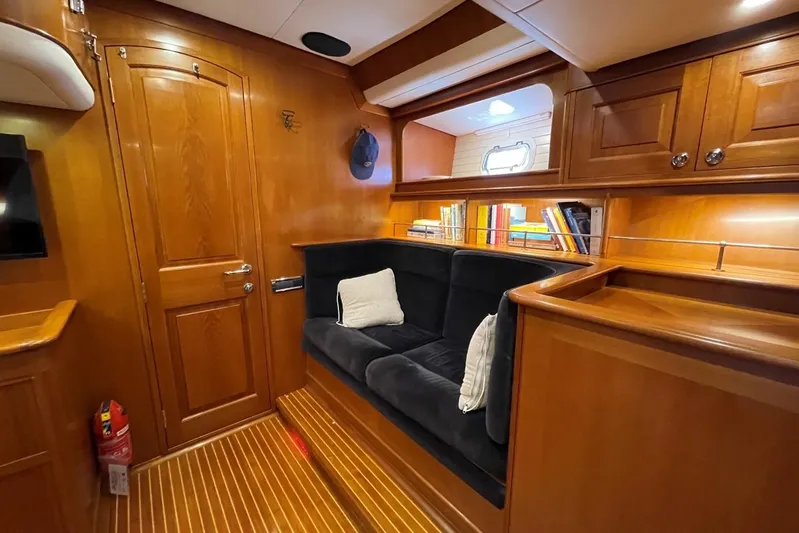  Yacht Photos Pics Luxurious Baltic 73 Pilothouse 1999 interior with wooden finish, cozy seating, and bookshelf.