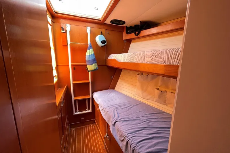  Yacht Photos Pics Cozy cabin interior of 1999 Baltic 73 Pilothouse with bunk beds and wooden finish.