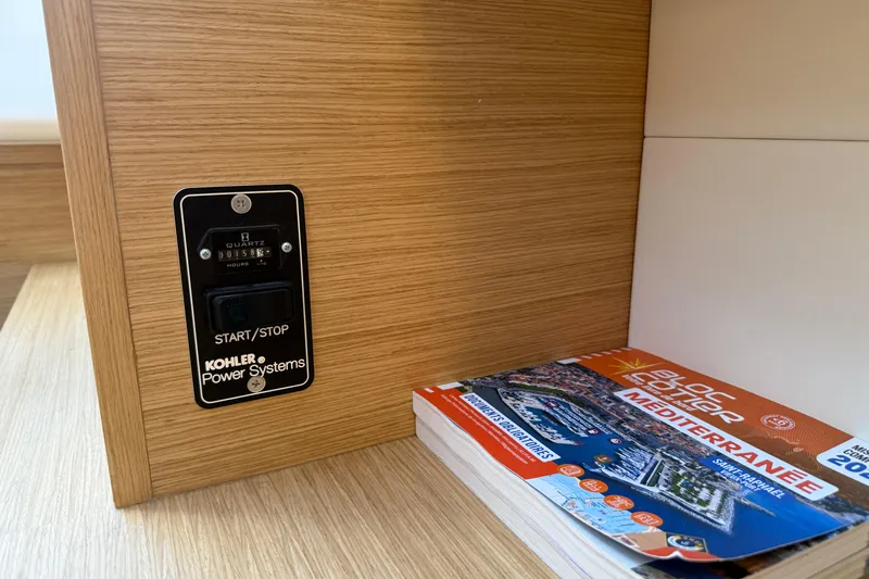 George Yacht Photos Pics Kohler power system panel on 2024 Pardo Yachts 43, with Mediterranean guidebook nearby.