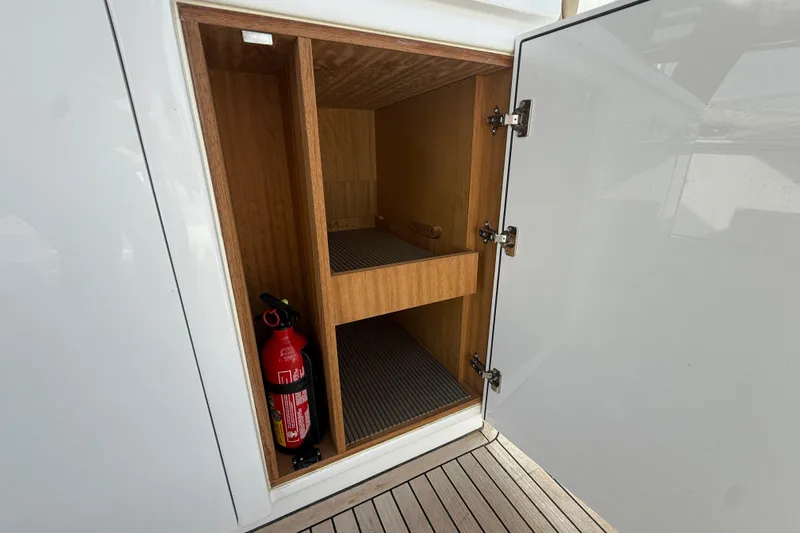 George Yacht Photos Pics Open storage compartment on 2024 Pardo Yachts 43, featuring shelves and a fire extinguisher.