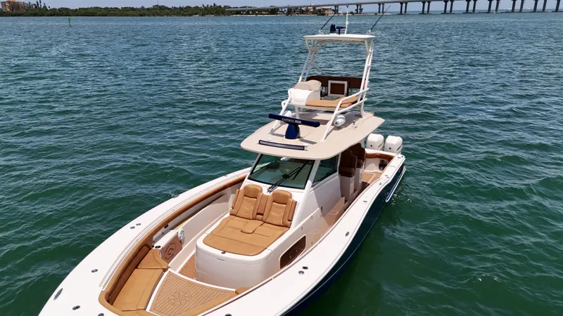  Yacht Photos Pics 2018 Scout 420 LXF boat cruising on open water with bridge in background.