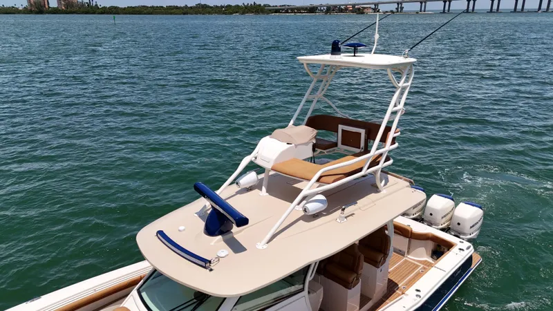  Yacht Photos Pics 2018 Scout 420 LXF boat on water with clear sky and distant bridge.