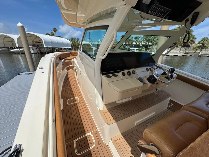  Yacht Photos Pics 2018 Scout 420 LXF boat interior with sleek helm, wooden deck, and luxurious seating.
