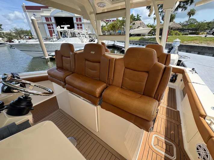  Yacht Photos Pics 2018 Scout 420 LXF boat interior with brown leather seating and wooden flooring.