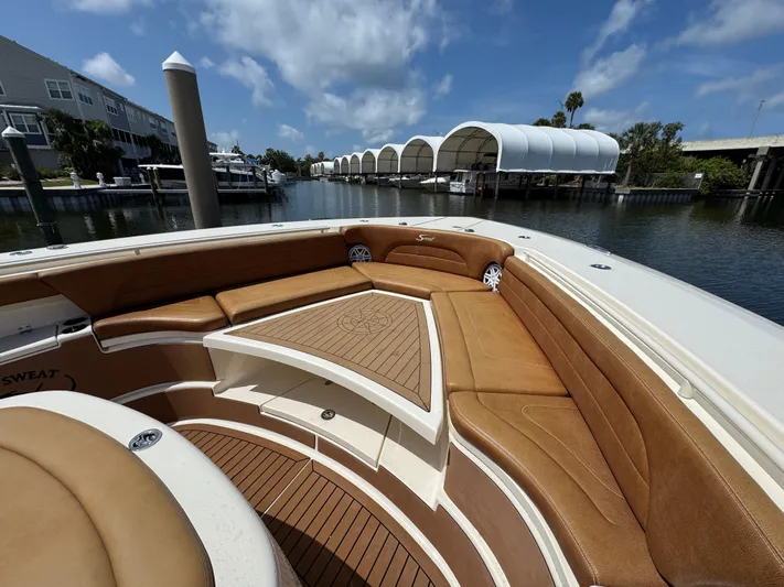  Yacht Photos Pics 2018 Scout 420 LXF boat with tan seating, docked in a marina under a blue sky.