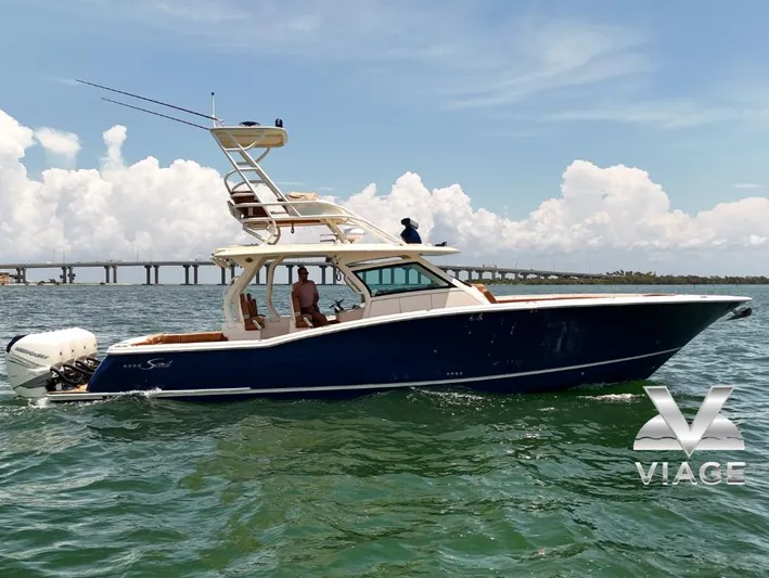 Yacht Photos Pics 2018 Scout 420 LXF boat cruising on water with bridge in background.