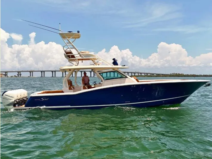  Yacht Photos Pics 2018 Scout 420 LXF boat cruising on open water with bridge in background.