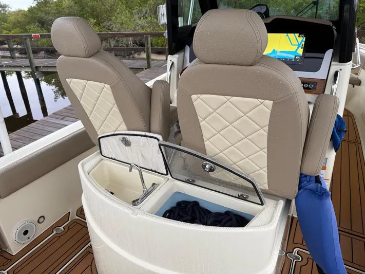  Yacht Photos Pics 2024 Chris-Craft Catalina 30 interior with beige seats and storage compartment.