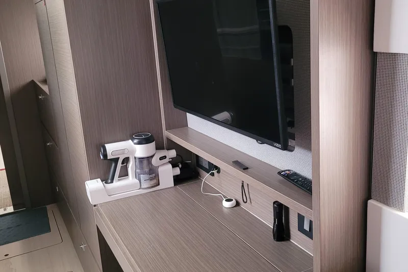 Making Connections II Yacht Photos Pics Modern interior of 2022 Leopard 45 yacht with TV, vacuum, and sleek wood finish.