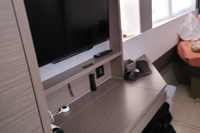 Making Connections II Yacht Photos Pics Modern cabin interior with TV, desk, and bed in 2022 Leopard 45 yacht.