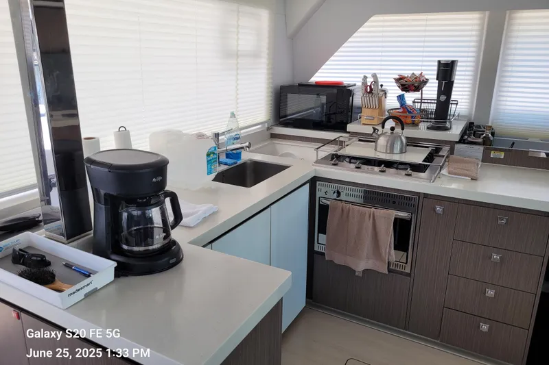 Making Connections II Yacht Photos Pics Modern kitchen in a 2022 Leopard 45 yacht with appliances and sleek cabinetry.