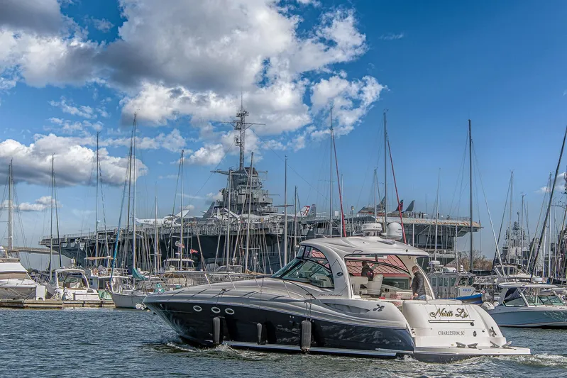 Nauti Lis Yacht Photos Pics 2005 Sea Ray 500 Sundancer yacht in marina, with large ship and sailboats in background.