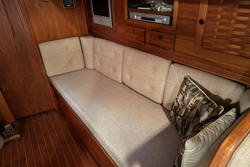 Gate Of Horn Yacht Photos Pics Interior of 1988 Sabre 42 yacht with beige cushioned seating and wooden cabinetry.