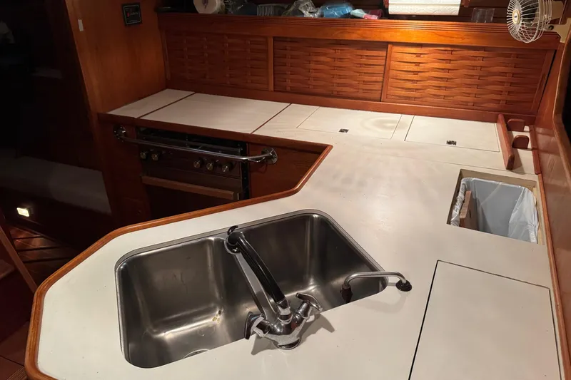 Gate Of Horn Yacht Photos Pics 1988 Sabre 42 yacht kitchen with stainless steel sink and wooden cabinetry.