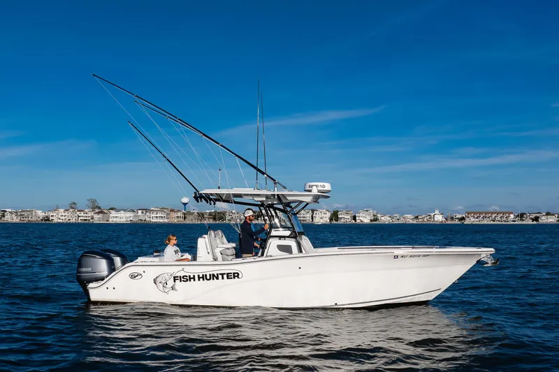 Fish Hunter Yacht Photos Pics 2021 Sea Fox 288 Commander boat on water, labeled "Fish Hunter," with fishing rods and two people onboard.