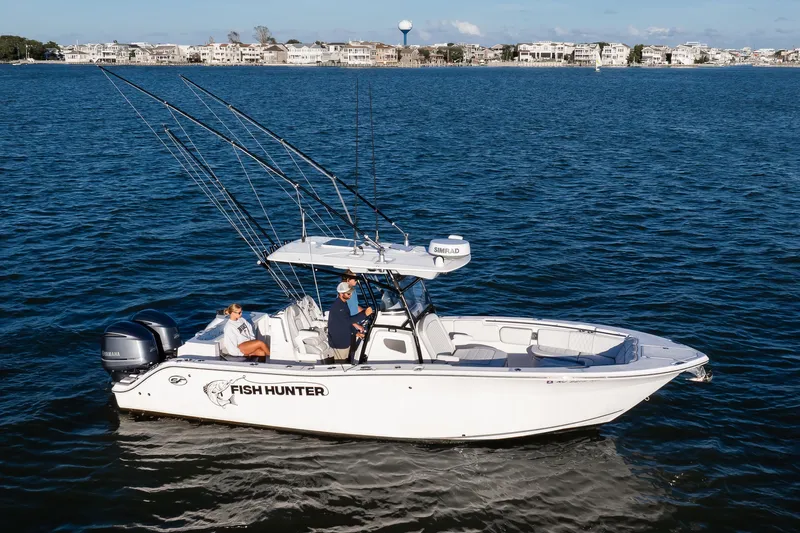 Fish Hunter Yacht Photos Pics 2021 Sea Fox 288 Commander boat on water, labeled "Fish Hunter," with two people onboard.