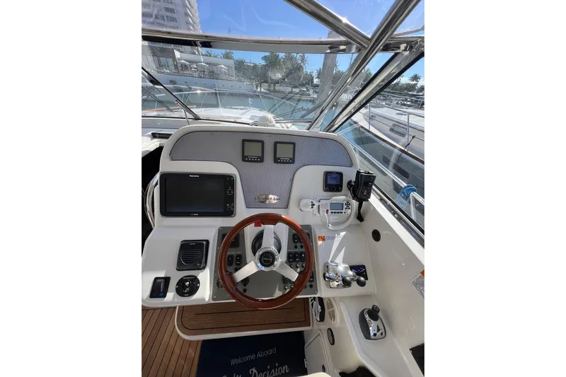 Split Decision Yacht Photos Pics Helm of 2007 Chris-Craft Roamer 40 yacht with modern navigation equipment and wooden steering wheel.