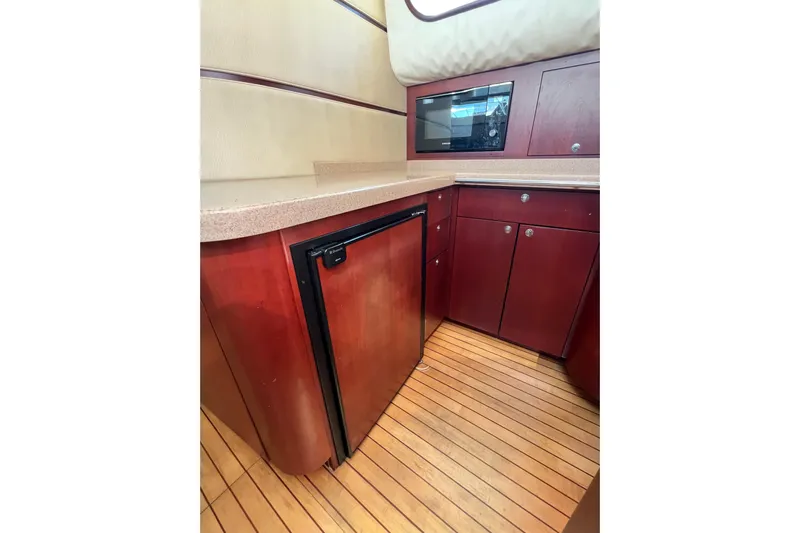 Split Decision Yacht Photos Pics 2007 Chris-Craft Roamer 40 yacht kitchen with wood cabinets and flooring.