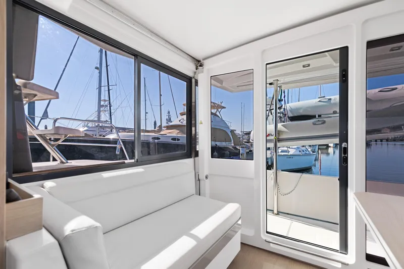 Chasing Shimmer Yacht Photos Pics Interior view of 2018 Bali 4.0 catamaran with marina backdrop through windows.