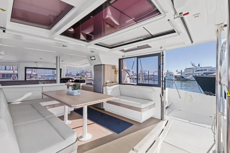 Chasing Shimmer Yacht Photos Pics Spacious interior of 2018 Bali 4.0 catamaran with modern seating and marina view.