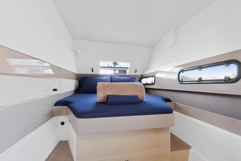 Chasing Shimmer Yacht Photos Pics Luxurious cabin interior of 2018 Bali 4.0 yacht with blue bedding and porthole windows.