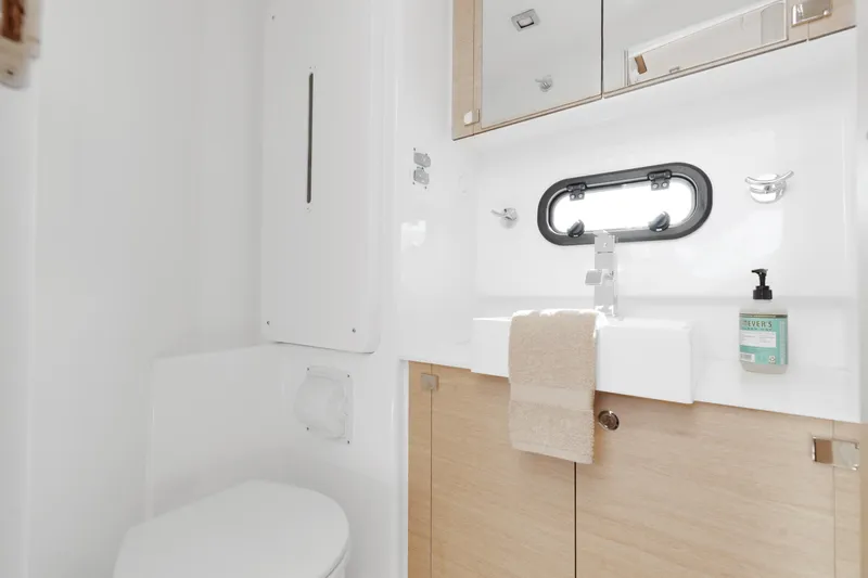 Chasing Shimmer Yacht Photos Pics Modern bathroom interior on 2018 Bali 4.0 yacht, featuring sink, mirror, and porthole window.