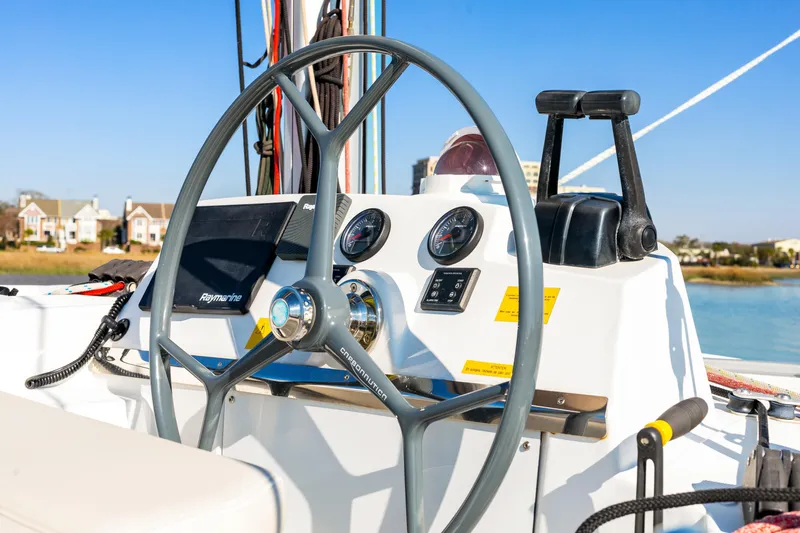 Chasing Shimmer Yacht Photos Pics Steering wheel and controls of a 2018 Bali 4.0 catamaran, with scenic waterfront view.