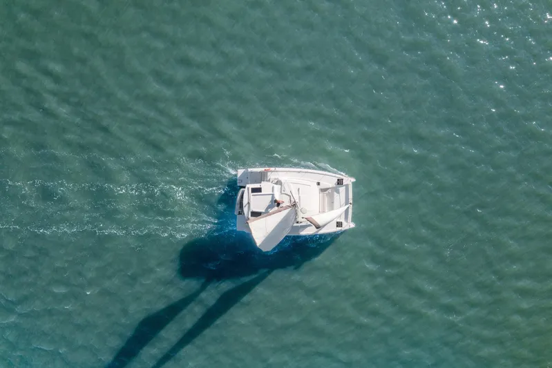 Chasing Shimmer Yacht Photos Pics Aerial view of a 2018 Bali 4.0 catamaran sailing on clear turquoise water.