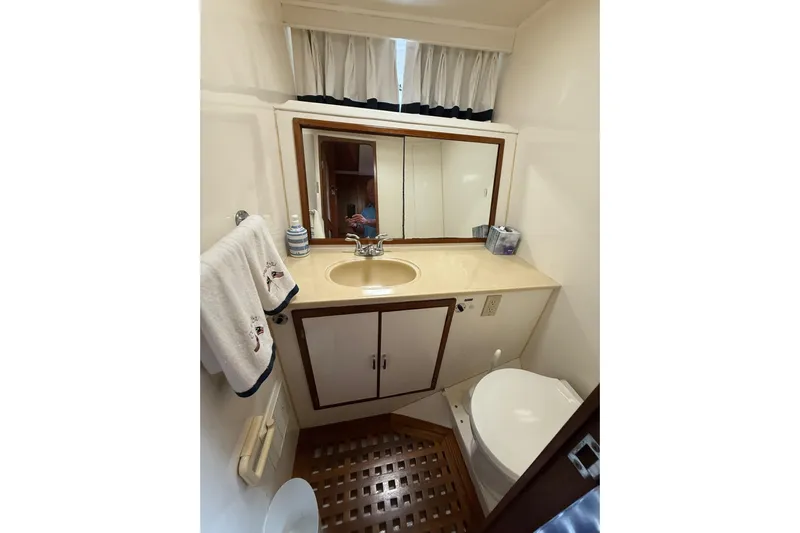 Sweet Caroline Yacht Photos Pics Bathroom interior of 1989 Jefferson Marquessa 52 yacht with sink, mirror, and toilet.