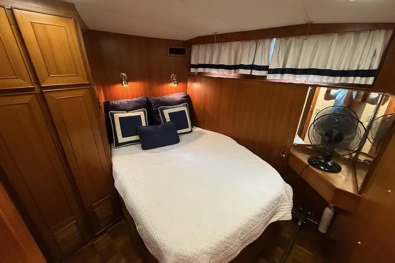 Sweet Caroline Yacht Photos Pics Cozy bedroom in 1989 Jefferson Marquessa 52 yacht with wood paneling and nautical decor.