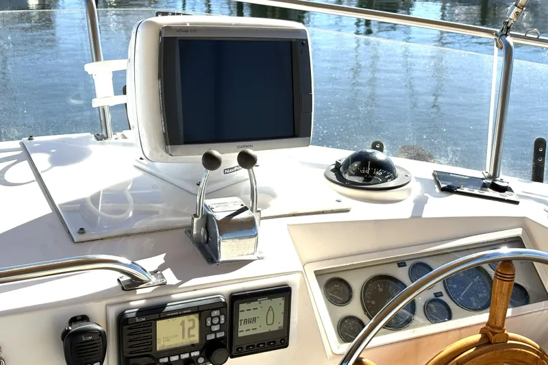 Deja Vu Yacht Photos Pics Helm of 1993 Grand Banks 42 Classic with navigation equipment and wooden steering wheel.