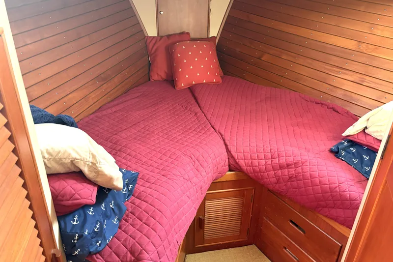 Deja Vu Yacht Photos Pics Cozy cabin interior of 1993 Grand Banks 42 Classic with red bedding and wooden paneling.