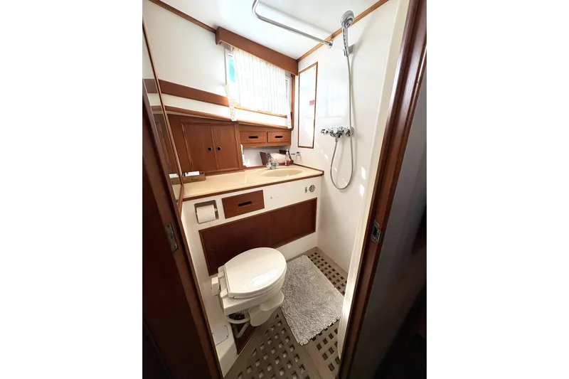 Deja Vu Yacht Photos Pics Bathroom interior of 1993 Grand Banks 42 Classic yacht, featuring shower and wooden cabinetry.