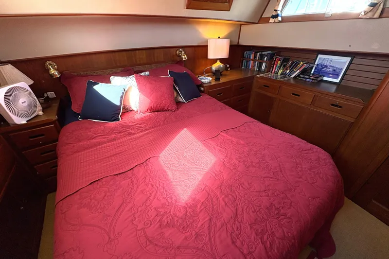 Deja Vu Yacht Photos Pics Cozy bedroom in 1993 Grand Banks 42 Classic yacht with red bedding and wooden cabinetry.