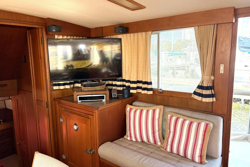 Deja Vu Yacht Photos Pics Interior of 1993 Grand Banks 42 Classic yacht with TV, striped cushions, and wood paneling.