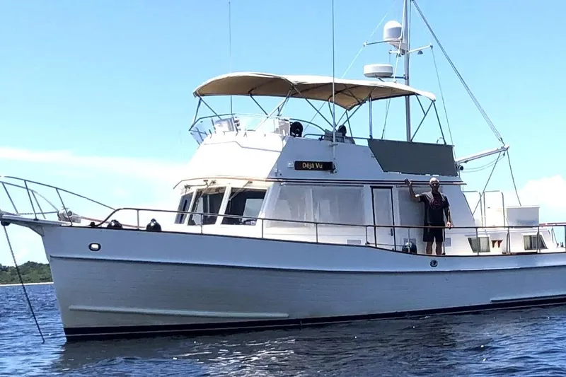 Deja Vu Yacht Photos Pics 1993 Grand Banks 42 Classic yacht on water, person waving on deck.