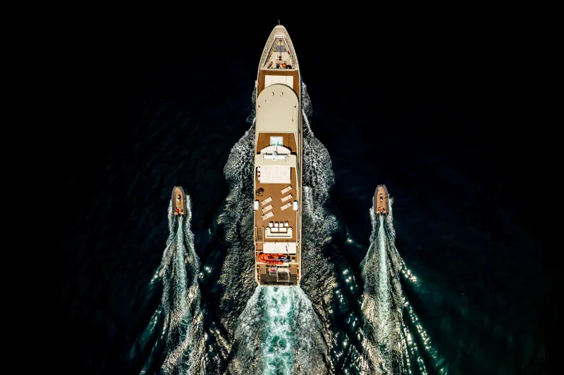 Vanora Yacht Photos Pics Aerial view of 2023 Seacrest Marine 52m Yacht with escort boats on dark water.