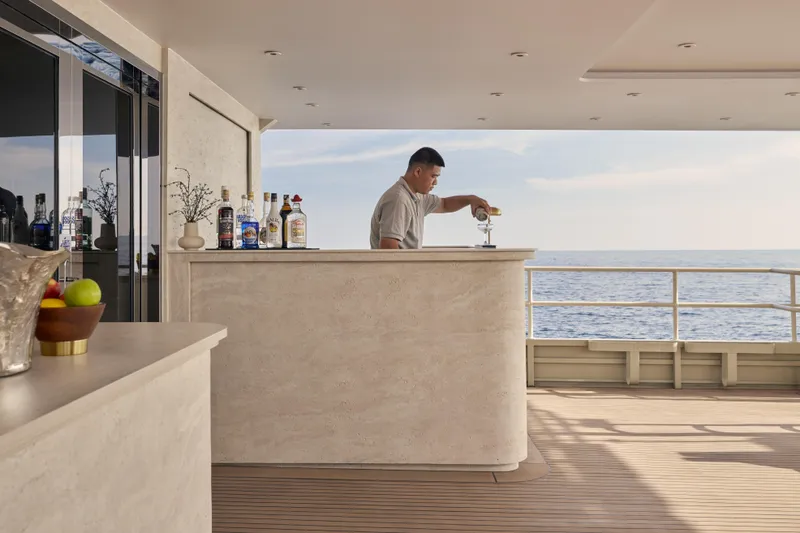 Vanora Yacht Photos Pics Luxury bar on 2023 Seacrest Marine 52m Yacht, bartender serving drinks with ocean view.