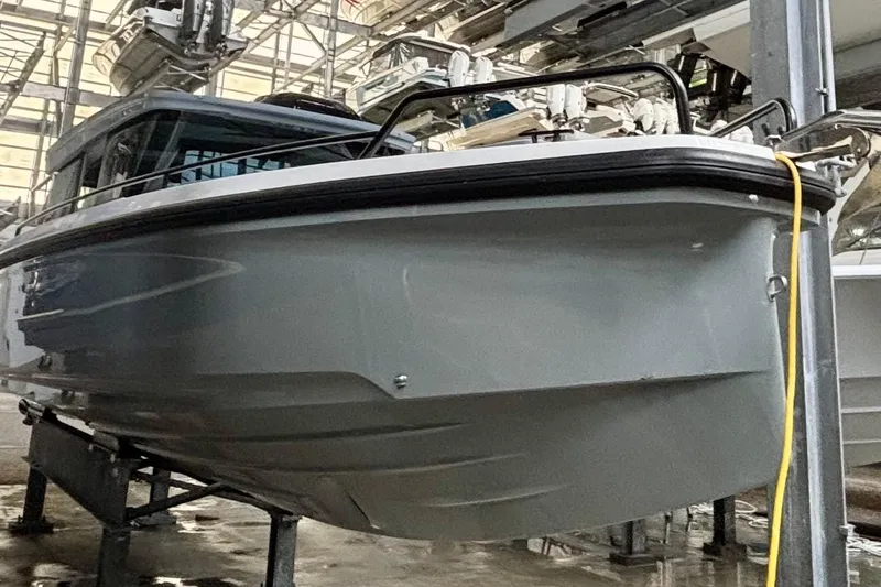  Yacht Photos Pics 2024 Axopar 37 XC Cross Cabin boat in storage, showcasing sleek design and modern features.