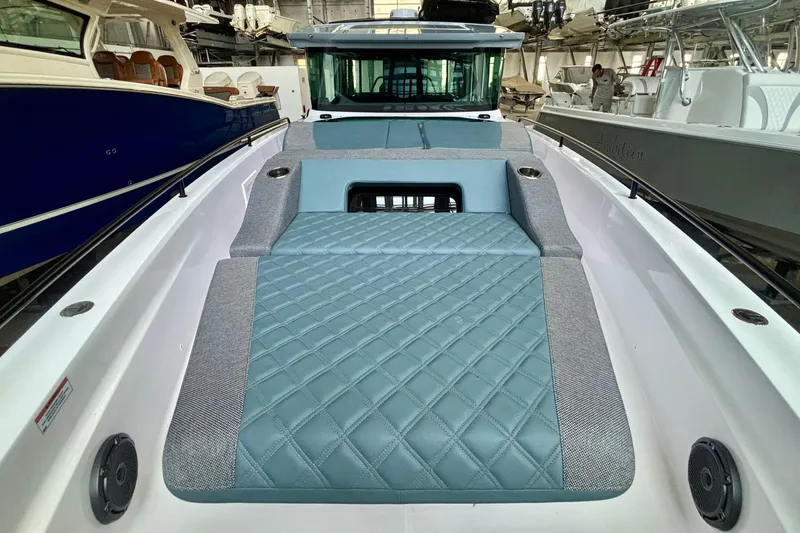  Yacht Photos Pics 2024 Axopar 37 XC Cross Cabin with blue quilted seating in a showroom.