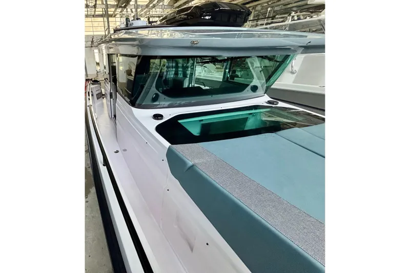  Yacht Photos Pics 2024 Axopar 37 XC Cross Cabin boat in a showroom setting.