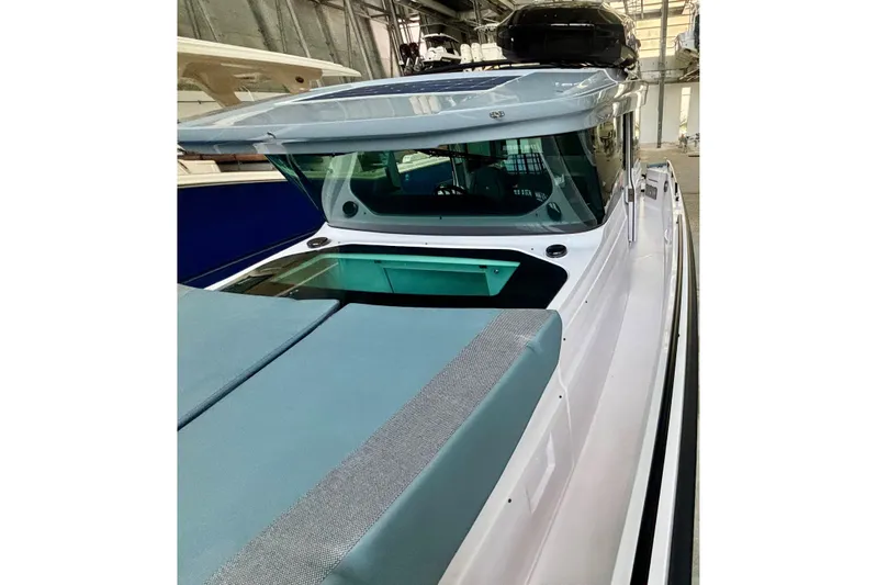  Yacht Photos Pics 2024 Axopar 37 XC Cross Cabin boat in a showroom, showcasing sleek design and modern features.