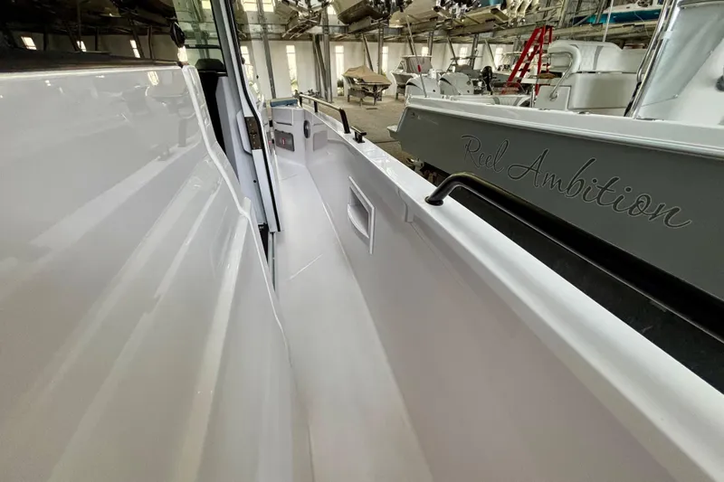  Yacht Photos Pics 2024 Axopar 37 XC Cross Cabin boat interior with sleek white design in a marina setting.