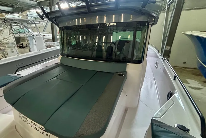  Yacht Photos Pics 2024 Axopar 37 XC Cross Cabin boat in a showroom, featuring sleek design and spacious deck.