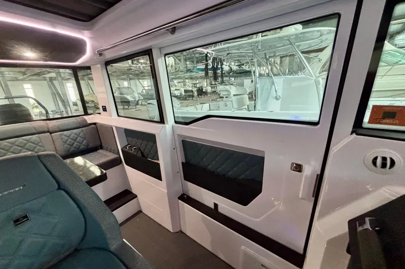  Yacht Photos Pics Interior of 2024 Axopar 37 XC Cross Cabin, featuring modern seating and large windows.