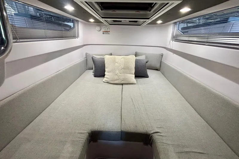  Yacht Photos Pics 2024 Axopar 37 XC Cross Cabin interior with cozy gray bedding and cushions.