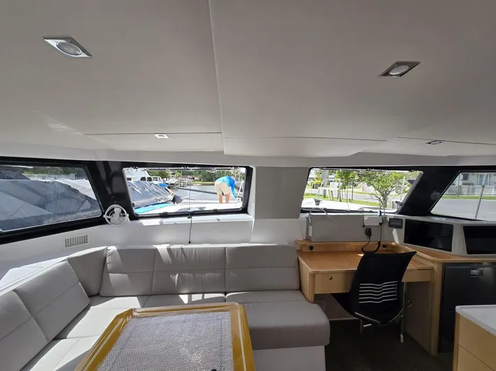  Yacht Photos Pics Modern interior of 2025 Seawind 1370 catamaran with sleek seating and workspace.